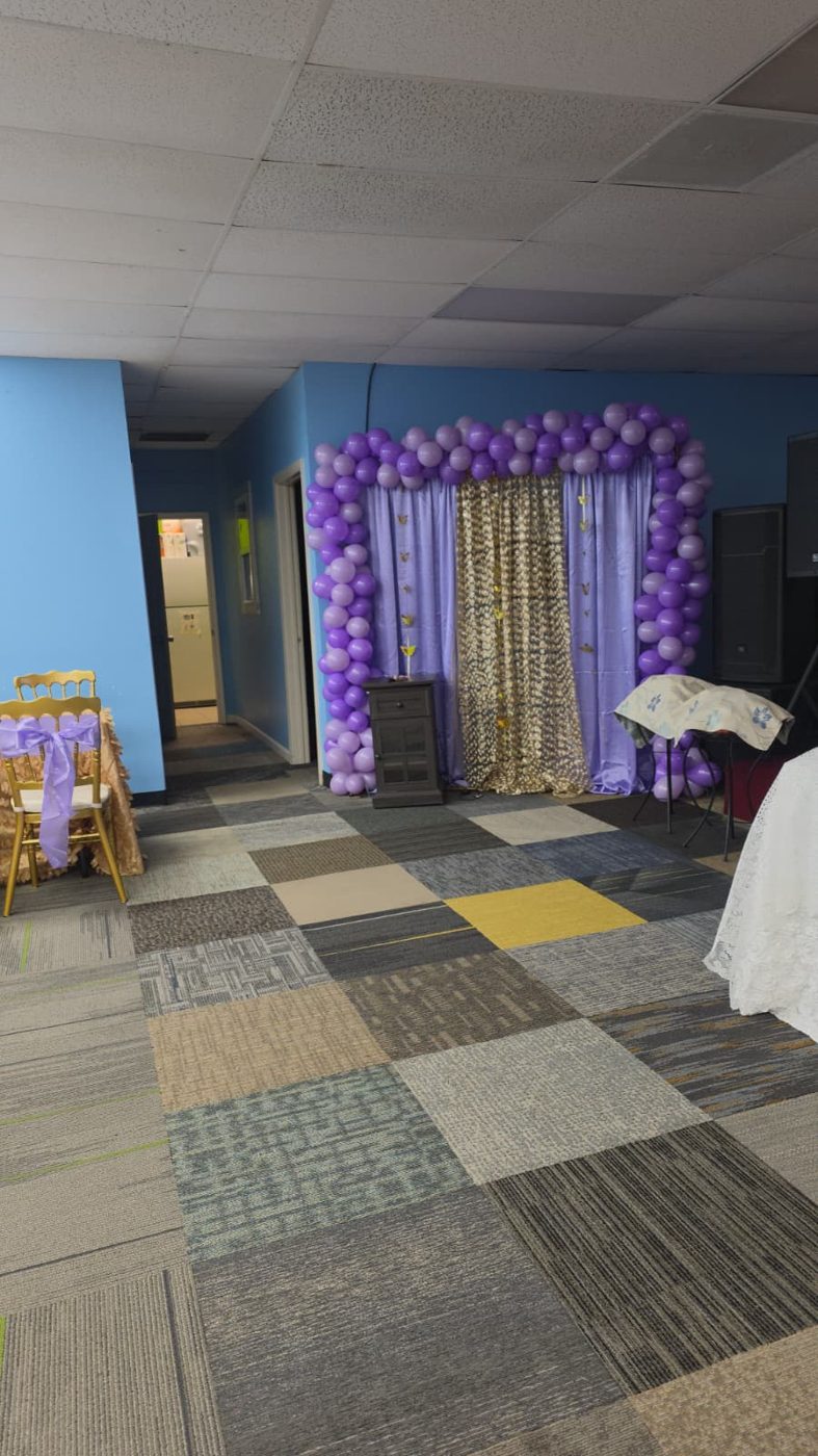 Arco de globos morados con cortinas lila y doradas